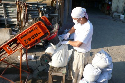 このオレンジの機械（コンベア）で土のう袋に砂を入れます。