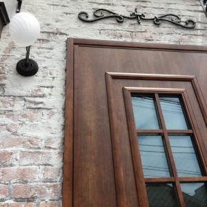 スイス漆喰の壁・赤レンガ造形と擬木のドア枠
